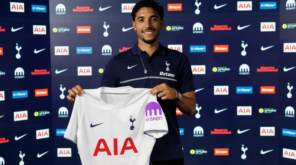 Omar Marmoush holds up a Tottenham shirt after signing