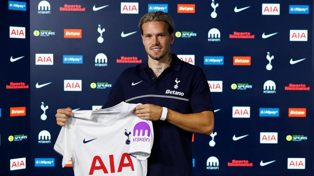 Mykhailo Mudryk holds up a Tottenham shirt after signing