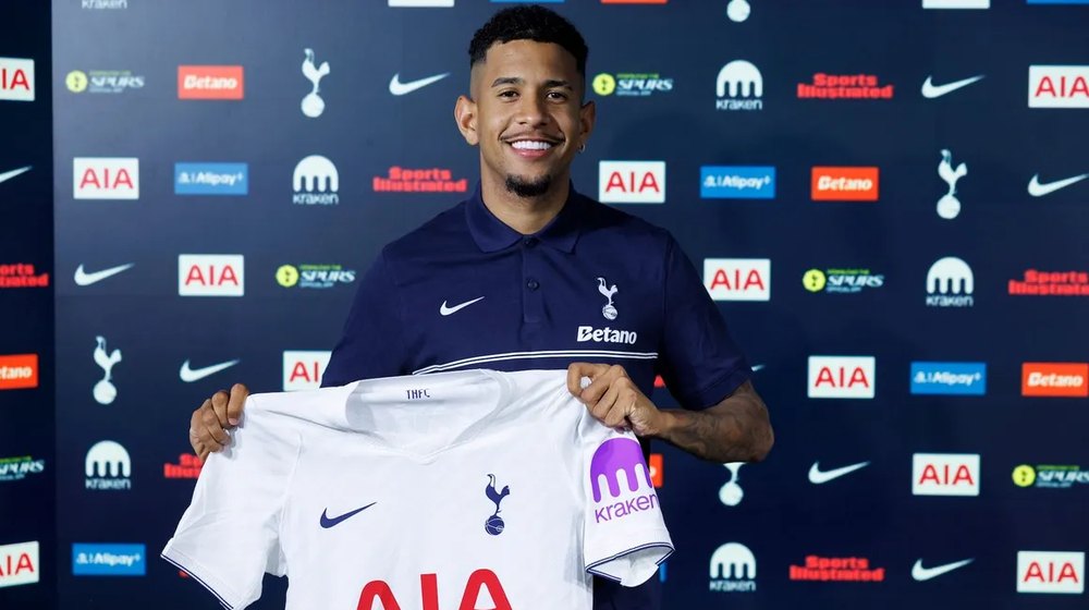 Sávio holds up a Tottenham shirt after signing